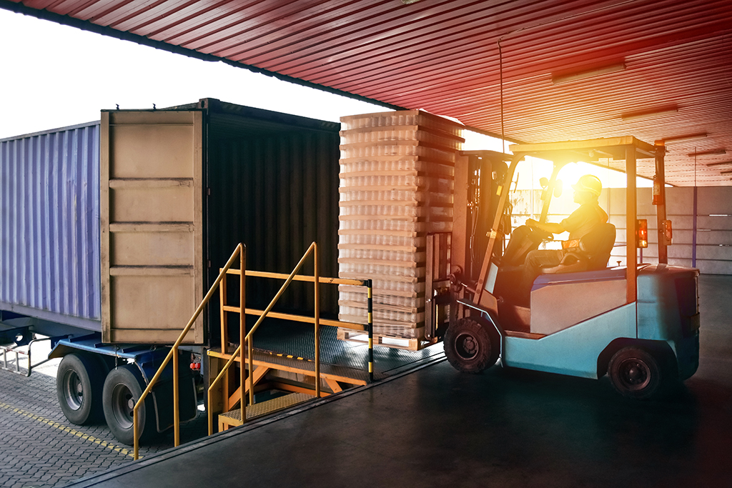 a forklift truck loading a pallet onto a truck