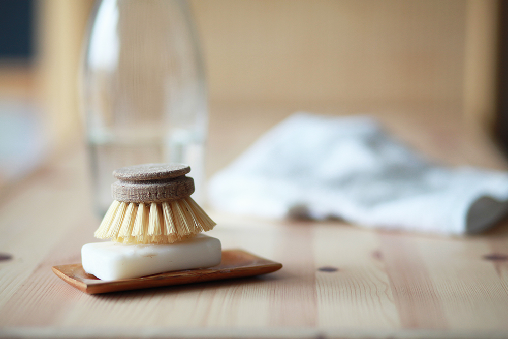 Jabón y cepillo de manos biodegradable sobre una mesa de madera